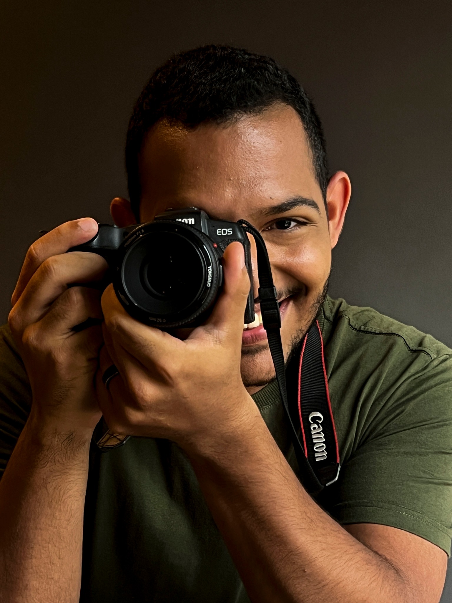 Foto bonita de társsis sentado em uma cadeira, com a camera na mão e sorrindo
